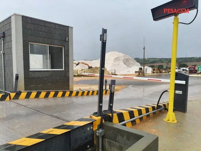Entrada de balança rodoviária com cancela, guarita, totem de identificação e painel de LED da pesagem