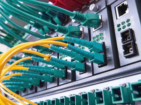 Cordões de fibra óptica conectados a conversores de mídia e patch panel óptico