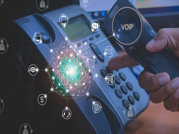Mão segurando o fone de um telefone IP com ícones de comunicação VoIP conectados em rede